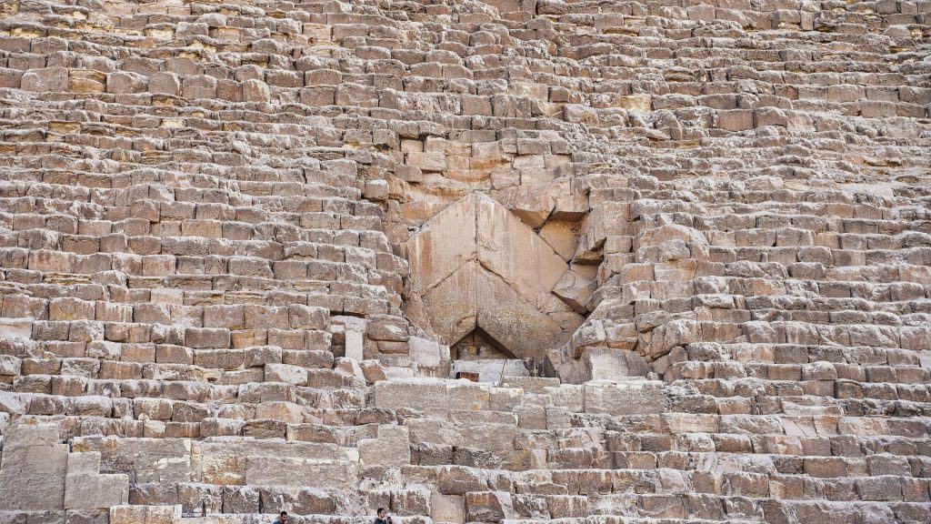 A entrada original da Grande Pirâmide de Quéops em Gizé vista neste close-up com blocos de calcário angulares, de onde uma passagem descendente inclina-se para a câmara subterrânea perto do Cairo, Egito.