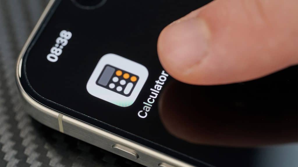 Pessoa com dedo em cima de ícone do aplicativo da calculadora no iPhone