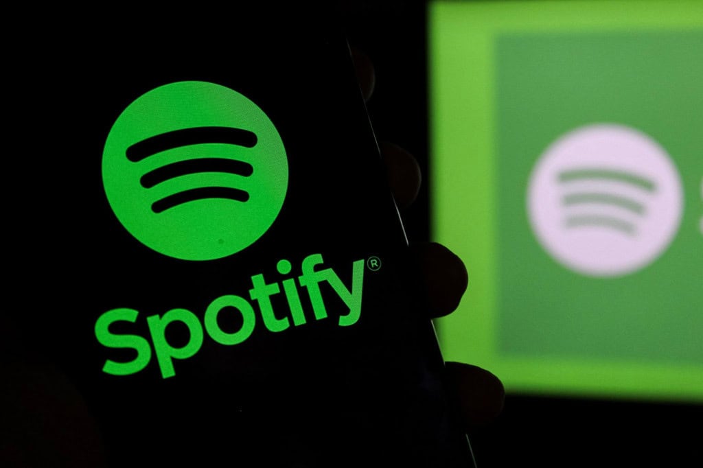 Logo do Spotify em um smartphone e ao fundo