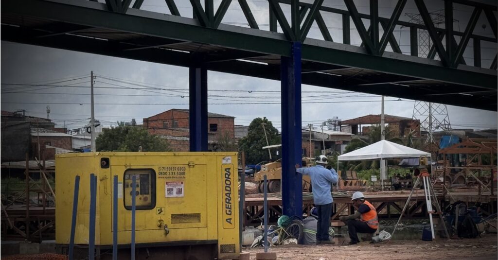 Uma parte da paisagem urbana ainda mistura máquinas, lama e improviso – símbolo de uma cidade que corre contra o tempo