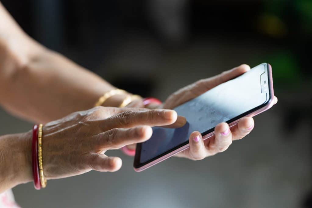 mão de mulher segurando um celular