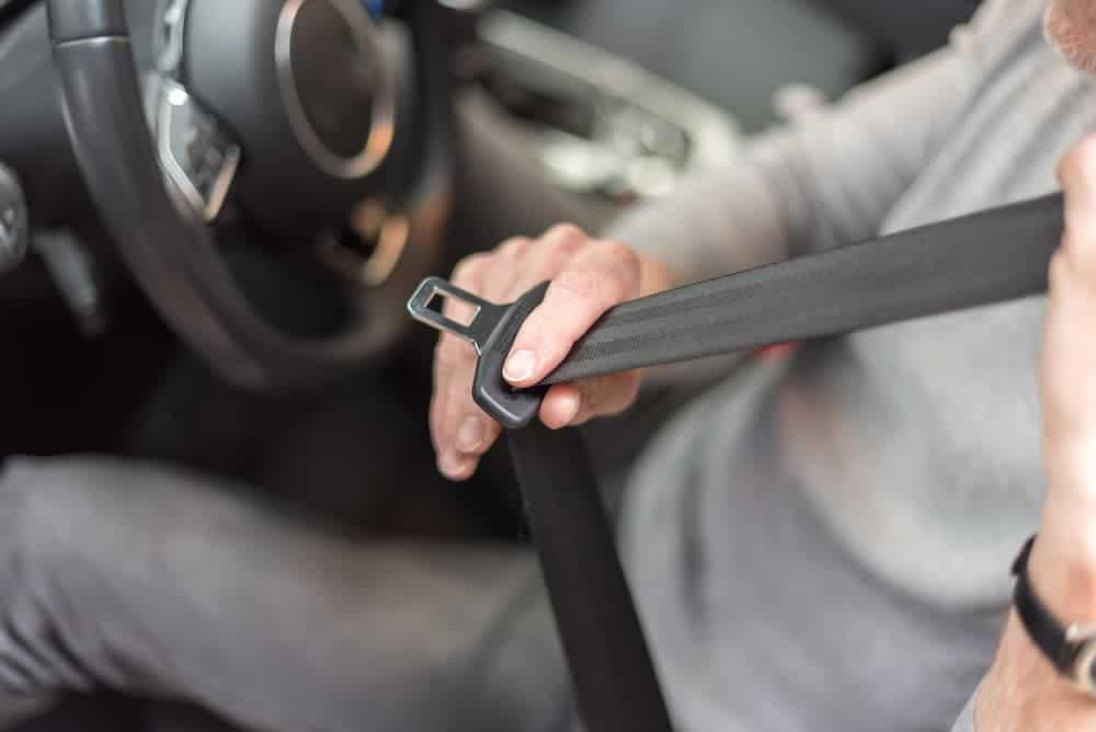 Motorista colocando o cinto de segurança em um carro