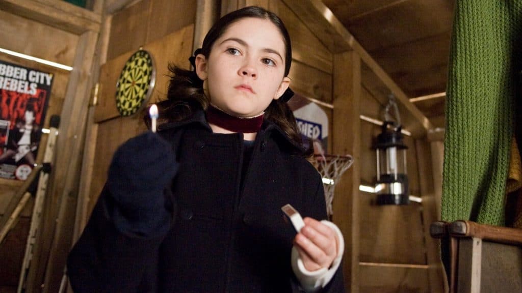 imagem mostra a personagem esther do filme ORFÃ com uma caixa de fósforo na mão