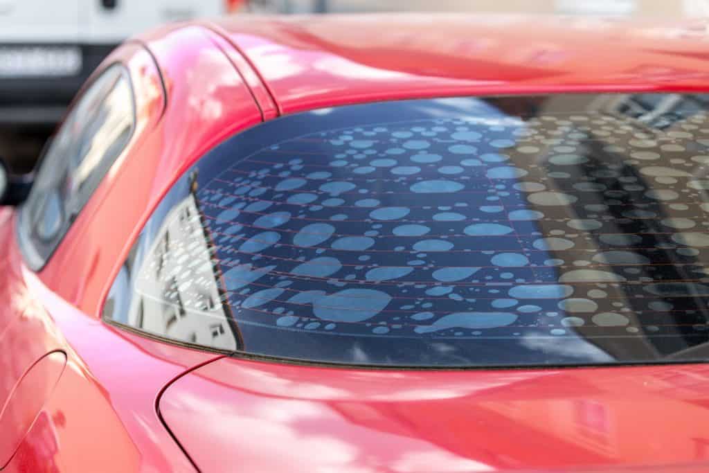 Vidro traseiro de carro apresenta insulfilm com bolhas, o que é proibido por lei, assim como película muito escura